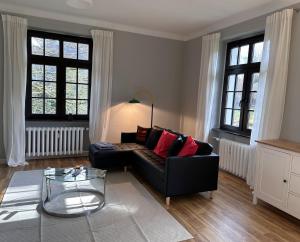een woonkamer met een zwarte bank en een glazen tafel bij FeWo Schöne Aussicht in Plettenberg
