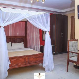 a bedroom with a canopy bed and a chair at Holale Hotel in Moyale