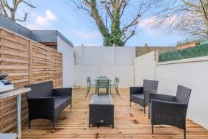een patio met stoelen en een tafel op een houten terras bij 3 bedroom house with terrace, near Lille in Marcq-en-Baroeul