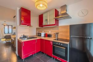 een keuken met rode kasten en een zwarte koelkast bij 3 bedroom house with terrace, near Lille in Marcq-en-Baroeul