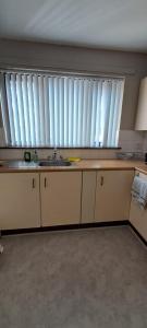 a kitchen with a sink and a large window at 293 Holiday Home in Belfast