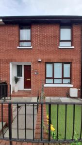 a brick house with a fence in front of it at 293 Holiday Home in Belfast