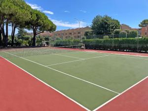 um campo de ténis com uma raquete de ténis em Relax and chill by the pool - Beahost em Bibione