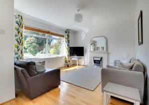 sala de estar con sofá y TV en Berries en Woodbridge