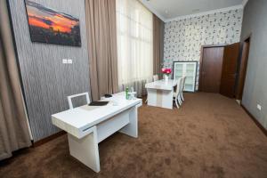 un ufficio con due scrivanie e sedie in una stanza di CASPIAN BUSINESS HOTEL a Baku