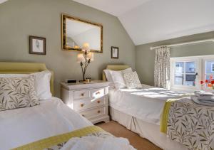 um quarto com 2 camas e um espelho em Alde Cottage em Friston
