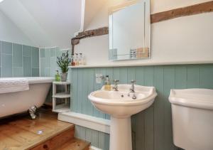 uma casa de banho com um lavatório, um WC e uma banheira em Alde Cottage em Friston