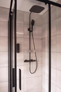 uma casa de banho com uma cabeça de chuveiro em Laurentroom Hotel em Ukmergė