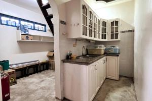 a kitchen with white cabinets and a sink at Panglao Cove Resort_Main House in Dauis