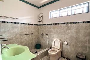y baño con bañera, aseo y lavamanos. en Panglao Cove Resort_Main House, en Dauis
