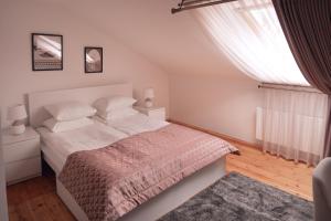 1 dormitorio con cama blanca y ventana en Laurentroom Hotel, en Ukmergė