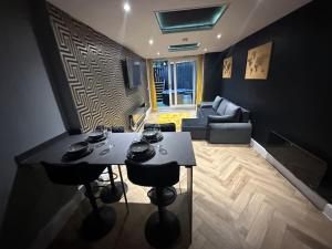 sala de estar con mesa y sofá en Murrayfield Stadium Basement - 3 Bed 3 Bath, en Edimburgo