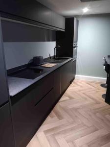 a kitchen with a black stove and a wooden floor at Murrayfield Stadium Basement - 3 Bed 3 Bath in Edinburgh