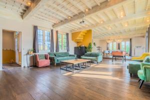 Cette grande chambre comprend des canapés, des chaises et une table. dans l'établissement 15 Min to Lille - Beautiful 14p House, 5 Bedrooms, à Sainghin-en-Mélantois