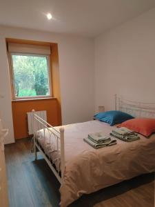 um quarto com uma cama branca e uma janela em La Grillère em Conliège