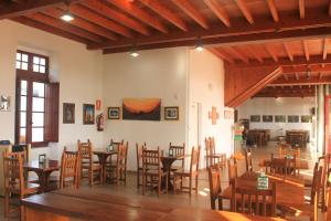 comedor con mesas y sillas de madera en Albergue Abeiro do Sor en Mañón