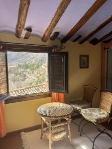 アルバラシンにあるカサ デ サンティアゴの椅子2脚と窓が備わる客室です。