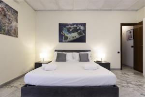 ローマにあるVATICAN Gregory Apartmentのベッドルーム1室(白い大型ベッド1台、ナイトスタンド2台付)