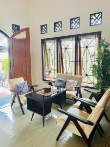 a living room with chairs and a table and windows at Zzz in Banyuwangi