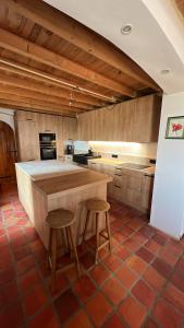 a kitchen with a counter and two stools in it at Les Garennes in Saint-Uze