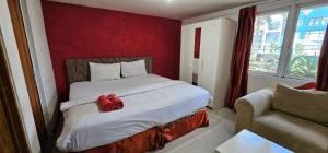 - une chambre dotée d'un lit avec un archet rouge dans l'établissement Mega Stay near Mall Kelapa Gading, à Jakarta