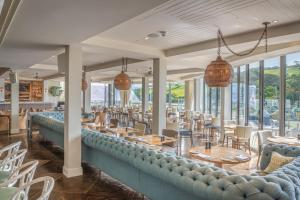 a restaurant with tables and chairs and windows at Harbour Hotel & Spa Salcombe in Salcombe