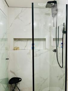 La salle de bains est pourvue d'une douche avec une porte en verre. dans l'établissement Cantinho do Aconchego DF, à Brasilia