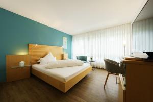 AbstattにあるHotel Hiller in Abstattの青い壁のベッドルーム1室(ベッド1台付)