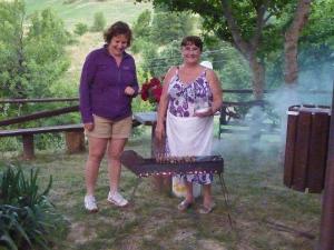 Twee vrouwen staan naast een grill. bij Residence Amici del Sorriso in Villa Celiera