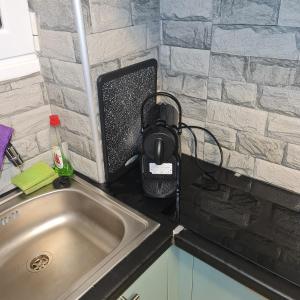 a kitchen counter with a sink and a speaker at Full apartment near Kato Patissia in Athens