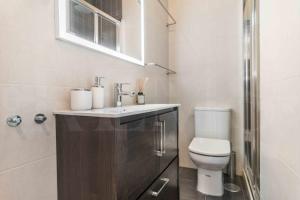 ein Bad mit einem Waschbecken und einem WC in der Unterkunft Central & authentic apartment with balcony by REMS in Málaga
