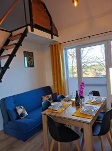 a dining room with a table and a blue couch at Leśny Zakątek-Domek Dąb in Parchowo +22 photos