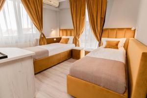 ein Hotelzimmer mit 2 Betten und einem Schreibtisch in der Unterkunft Pensiunea Elisei in Timişoara