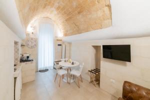 a kitchen and dining room with a table and a tv at Fjore di Lecce, camere & caffè in Lecce