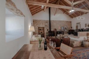 LIKE-HOME-Kina House-Casa do Lagar-Ericeira في مافرا: غرفة مع طاولة مع كؤوس للنبيذ وغرفة معيشة
