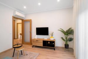 a living room with a flat screen tv on a white wall at Apartamento Beira Mar - 2º Esquerdo in Tavira