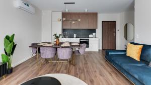 uma sala de estar com uma mesa e um sofá azul em Lion Apartments - SCALA City Center Apartments&Parking IK em Gdansk