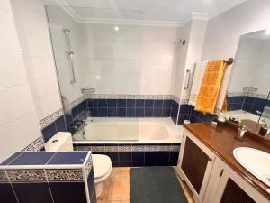 a bathroom with a tub and a toilet and a sink at Ideal Parejas in Lekeitio