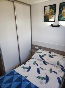 Un dormitorio con una cama con pájaros azules. en Leśny Zakątek-Domek Dąb en Parchowo