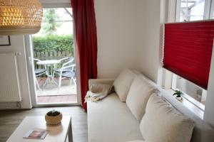 a living room with a couch in front of a window at Strandvogtei Sellin - FeWo 5 - sehr zentrales großes Apartment in Ostseebad Sellin