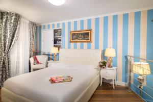 una camera con letto bianco e strisce blu di Il Terrazzino sulla Cattedrale a Firenze