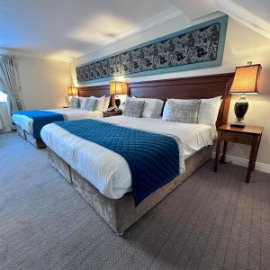 a hotel room with two beds with blue sheets at Headfort Arms Hotel in Kells