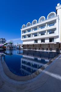 a building with a pool of water in front of it at Belenli Resort Hotel in Belek