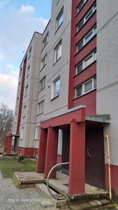 ein hohes Gebäude mit rot und grau in der Unterkunft Apartment Ramune in Šiauliai
