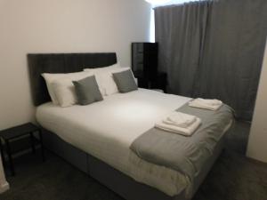 um quarto com uma cama grande com duas toalhas em New & delightful 3 bed house in East Kilbride em Glasgow
