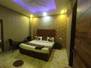 1 dormitorio con 1 cama con techo púrpura en Hotel Pearl Grand Prime, en Karnal