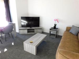 New & delightful 3 bed house in East Kilbride في غلاسكو: غرفة معيشة مع أريكة وتلفزيون بشاشة مسطحة