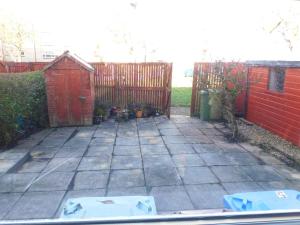 a backyard with a red fence and a patio at New & delightful 3 bed house in East Kilbride in Glasgow