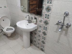 a bathroom with a sink and a toilet at Hotel Pearl Grand Prime in Karnal