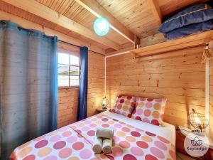 a bedroom with a bed in a wooden cabin at Joli Coeur - Bungalow aux Makes - Saint-Louis in Saint-Louis